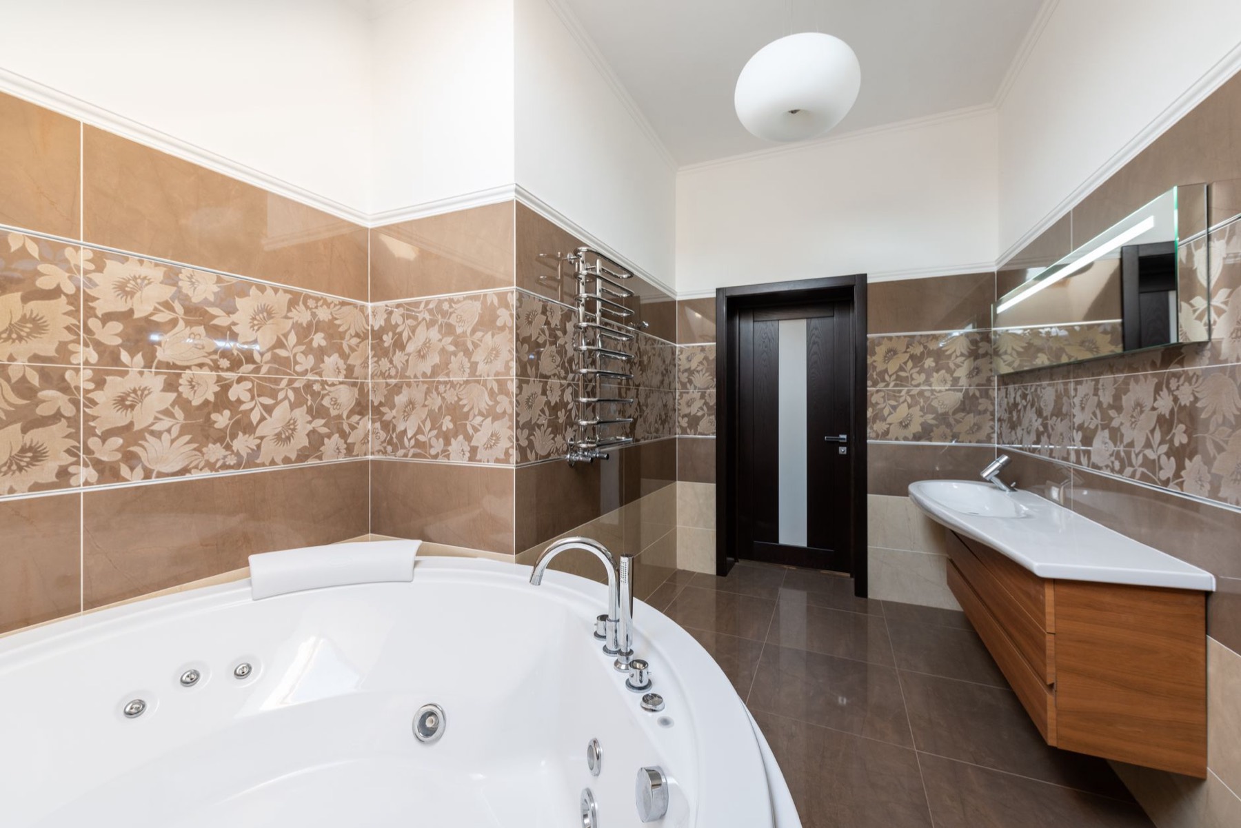 Modern bathroom with freestanding bath, twin vanity and wall tiling