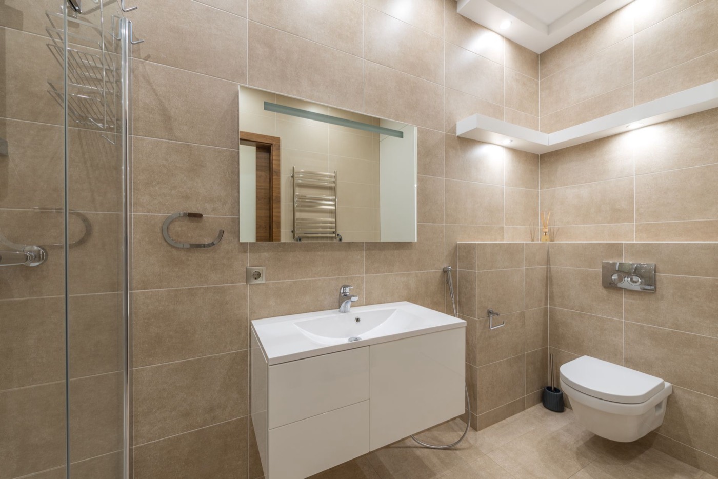 Tiled bathroom display in the showroom with vanity unit and mirror