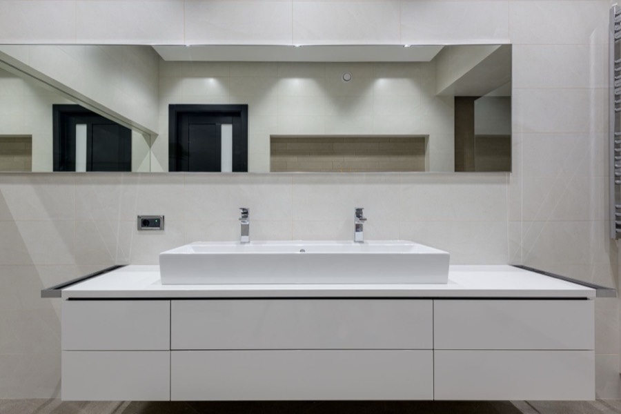 Stainless steel kitchen sink set into a white counter
